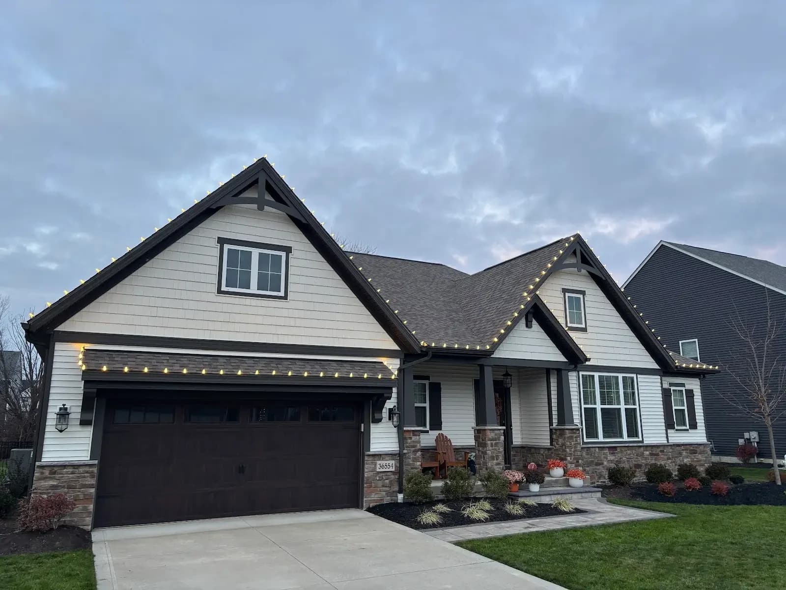 Warm lights outlining the gables of a North Ridgeville home at dusk, installed by Shoreline