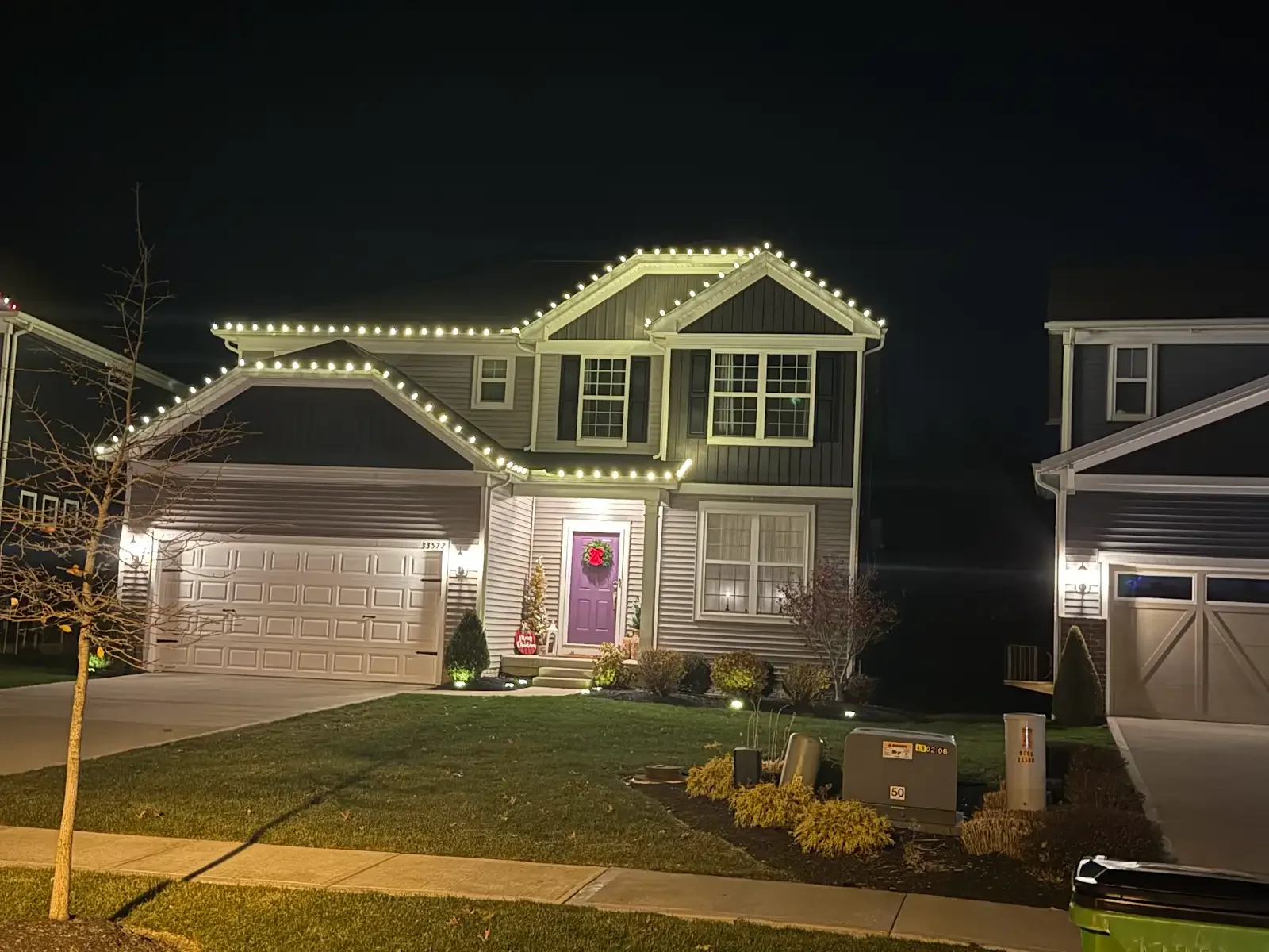 Warm roofline lights on a two-story home in Avon Lake, a Shoreline project